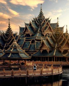 a person standing on a dock in front of a large building with many spires