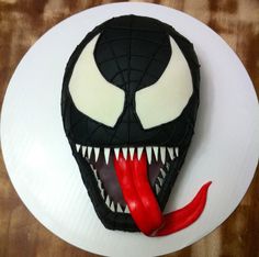 a cake decorated to look like a spiderman face with red chili peppers on the side