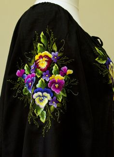 an embroidered black jacket with colorful flowers on it