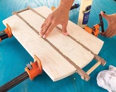 a person working on a piece of wood that is being made into a table top