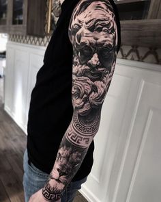 a man with a black and grey tattoo on his arm