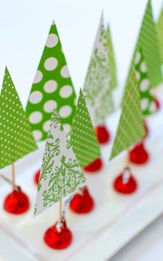 small green and white christmas trees on a plate with cherries in the foreground