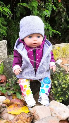 a baby doll is sitting on some rocks