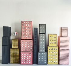 several different colored boxes stacked on top of each other in front of a white wall