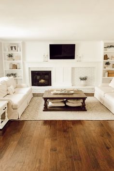 a living room filled with furniture and a flat screen tv mounted on the wall above a fireplace