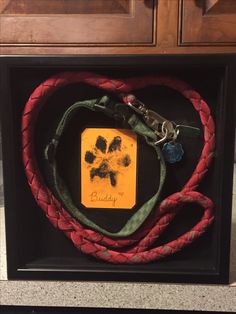 a dog's paw print is attached to a leash in a shadow box on the floor