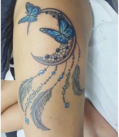 a woman's thigh with a blue butterfly and dream catcher tattoo on it