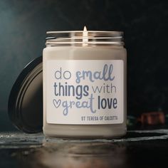 a candle with a quote on it sitting on a table next to a cupcake