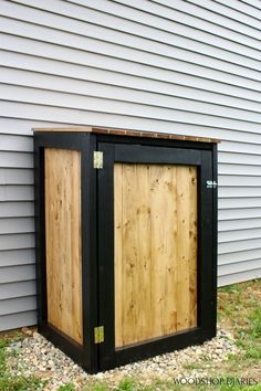 a wooden storage box sitting in front of a house