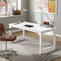 an office desk with a chair and calendars on the wall above it in front of a window