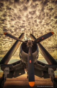 an airplane is sitting on the runway with clouds in the background