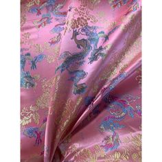 a pink and blue fabric with dragon designs on the top, as well as other material