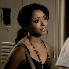 a woman standing in front of a locker with a necklace on it's neck