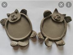 two clay cats sitting on top of each other