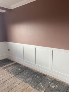 empty room with wooden floor and white paneling on the walls, painted in brown