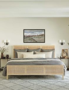 a bedroom with a bed, nightstands and pictures on the wall above it is shown