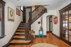 a staircase leading to the second floor in a house with wood floors and white walls