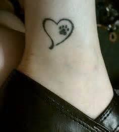 a dog paw and heart tattoo on the ankle