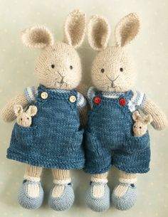 two stuffed rabbits are dressed in blue overalls and holding their hands behind their backs