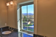 there is a bathroom with a large window in the wall and a sink on the counter