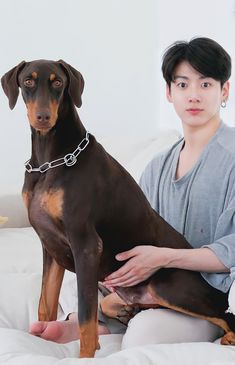 a woman sitting on a bed holding a dog