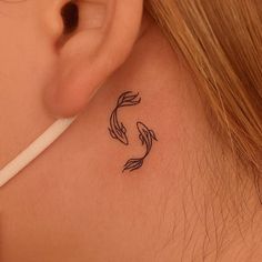 a woman with a tattoo on her neck has a fish in it's ear