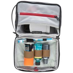 an open travel bag filled with toiletries and personal care items on a white background