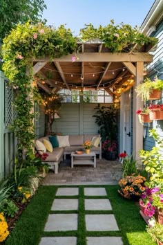 an outdoor living area with lots of plants and flowers