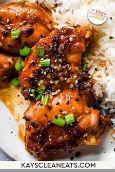 chicken with sesame seeds and green onions served over rice on a white plate, with the title above it