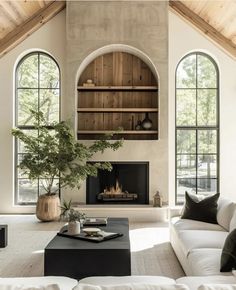 a living room with two large windows and a fire place in the middle of it