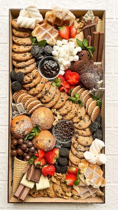 a box filled with lots of different types of cookies and pastries on top of each other