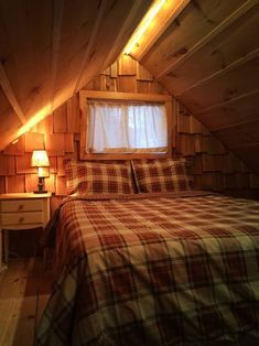 a bed in a room with wooden walls