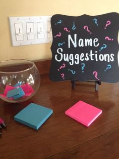 a blackboard that says name suggestions next to some sticky notes on a wooden table