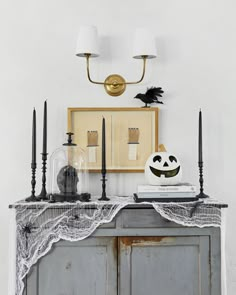 an old dresser is decorated with black candles and halloween decorations, including a jack - o'- lantern