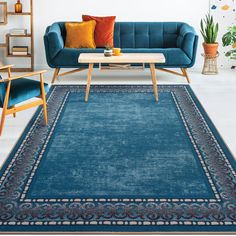 a living room with blue couches and rugs on the floor next to a coffee table