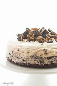 a cake with white frosting and chocolate chips on top is sitting on a plate