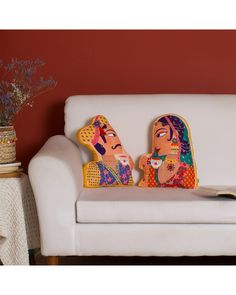 two people sitting on a couch with pillows