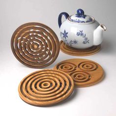 four coasters and a teapot on a table