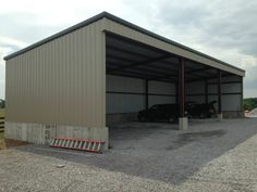 two cars are parked in an empty garage with one car attached to the side of the building