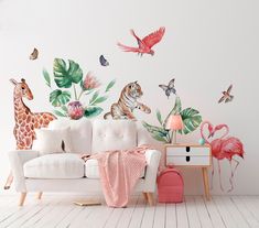 a white couch sitting next to a wall covered in animals and plants on top of it