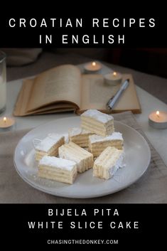 there are several pieces of cake on the plate with candles in the background and an open book next to it