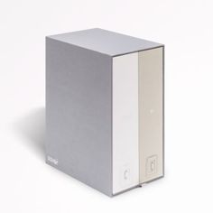 a silver and white box sitting on top of a white table next to a wall