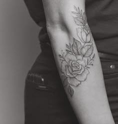 a woman with a rose tattoo on her arm