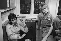 two women sitting next to each other in front of a window