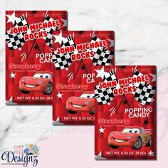 three disney cars birthday party favors with red envelopes and white stars on the front