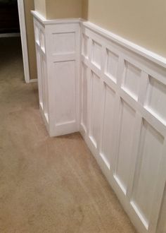 an empty room with white paneling on the wall and carpeted floor in front of it