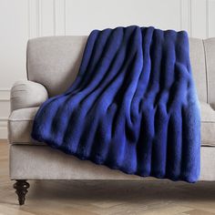 a couch with a blue blanket sitting on top of it