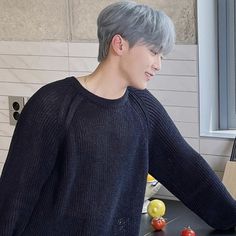 a man with grey hair standing in front of a kitchen counter next to a cutting board