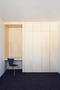 an empty room with a chair and some cupboards on the wall next to it