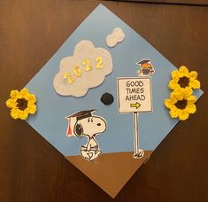 Graduation cap with snoopy walking towards a sign that says “good times ahead” with Woodstock. Felt cloud at the top reads 2022, and there are crochet sunflowers on the left and right corners of the cap. Charlie Brown Graduation Cap, To Infinity And Beyond Graduation Cap, Minimal Grad Cap Design, Garfield Graduation Cap, Gudetama Graduation Cap, Miffy Graduation Cap, Peanuts Graduation Cap, Snoopy Graduation Cap Designs, Snoopy Graduation Party